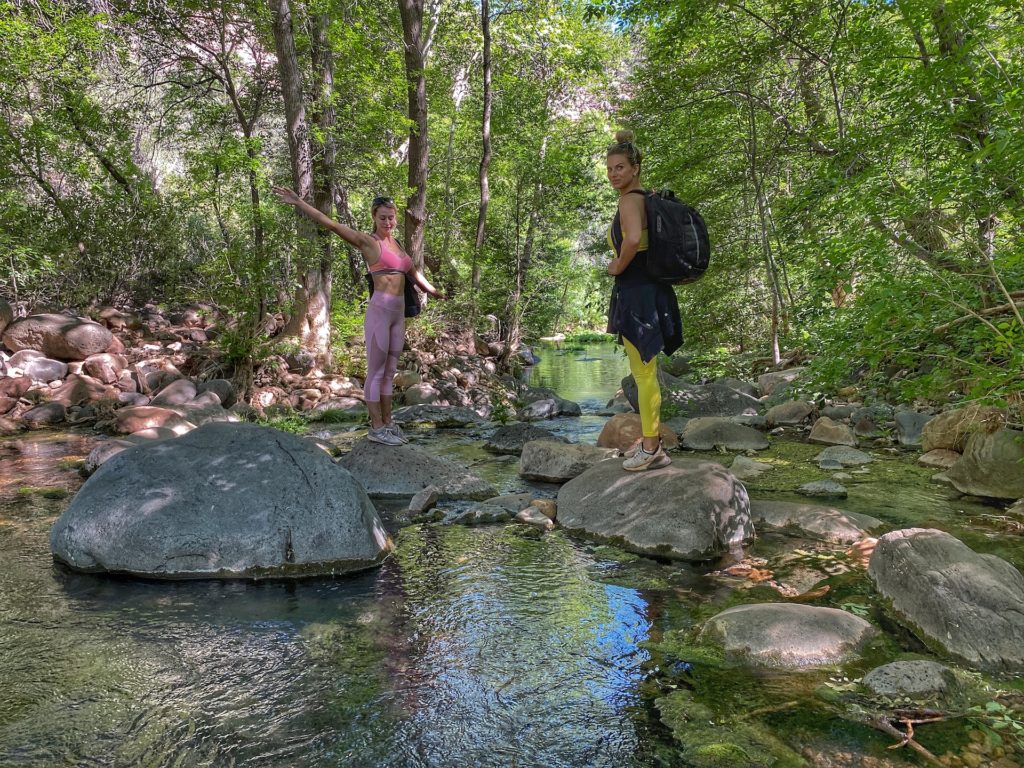 Two ladies standing on big rocks in the middle of a spring along bob bear trail hike