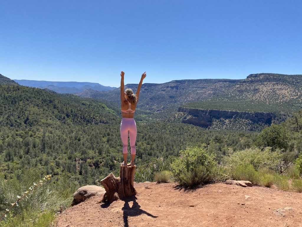 Lady standing on a stump overlooking the bob bear trail landscape